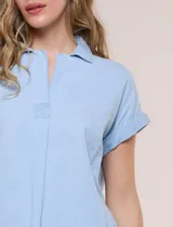 Blusa blanca de algodón y viscosa, con cuello camisero, escote en V y mangas cortas con vuelta.