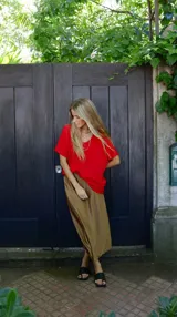 Falda midi evasé de raso color negro, con cintura elástica y cinturón con apliques metálicos.