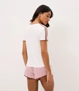 Pijama corto Lov de dos piezas confeccionado en peach touch. Compuesto por remera blanca de manga corta con ribetes y cuello marrón, con estampa frontal de oso y la leyenda "Be Cool", y short de rayas verticales rosadas y blancas con cintura elastizada.