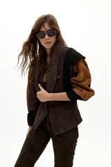 Chaqueta de gamuza con diseño de paneles en colores marrón, chocolate y negro. Presenta hombros estructurados, corte entallado en la cintura y botones forrados al tono.