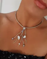 Gargantilla rígida plateada con colgante de perlas irregulares y cuentas de cristal.