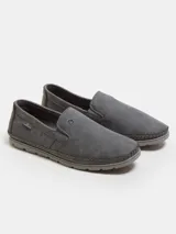 Mocasines urbanos de eco-cuero color gris oscuro, con costuras perimetrales reforzadas a la vista, elásticos laterales para un calce rápido y suela de PVC flexible.