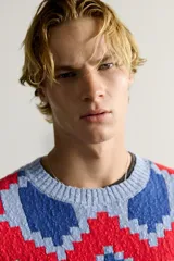 Jersey de punto tejido en hilatura de algodón, con diseño de patrones geométricos en colores celeste, azul, rojo y amarillo. Presenta cuello redondo, manga larga y acabados en rib.