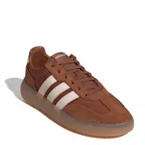 Championes urbanos Adidas modelo Barreda Decode, color marrón con detalles en rosado claro. Presentan una combinación de gamuza y material sintético, con las icónicas tres tiras laterales y suela de goma traslúcida.