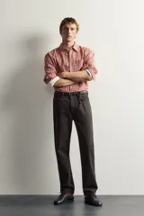 Jeans straight fit de corte recto y tiro medio, confeccionados en denim de algodón con efecto lavado en color marrón oscuro, con diseño clásico de cinco bolsillos y cierre frontal con botonadura.