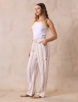 Pantalón cargo de lino a rayas verticales grises y blancas, marca Marissa Olivia. Pretina ancha elastizada con lazo de ajuste, bolsillos inclinados delanteros y bolsillos laterales con botón.
