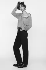 Jeans de tiro alto color negro con efecto lavado, corte mom fit, cinco bolsillos y cierre frontal con cremallera y botón metálico.