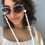 Correa para lentes con cuentas de caracoles blancos y detalles de cuentas facetadas transparentes.