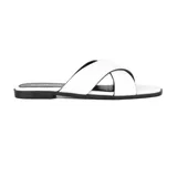 Sandalias bajas blancas con tiras cruzadas y suela negra.
