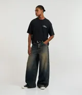 Pantalón de jean con corte baggy, de tiro alto y diseño holgado. Presenta un acabado desgastado y trabillas en la cintura.