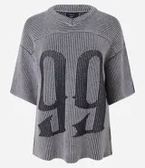 Remera de punto de calce boxy, color gris y negro, con diseño de rayas verticales y un gran estampado frontal del número "99" en la misma textura de rayas. Presenta escote en V y mangas cortas amplias.