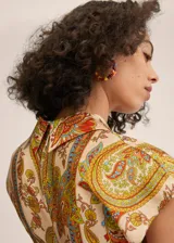 Mono largo con estampado paisley en tonos beige, naranja, verde y celeste. Diseño cruzado con escote en V, mangas cortas y cinturón de lazo.
