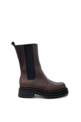 Bota de cuero color marrón chocolate, con elásticos laterales negros, cierre lateral y suela track color negro.