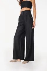 Pantalon de lino negro de corte ancho y fluido, tiro alto con pinzas en la cintura y cierre frontal oculto.