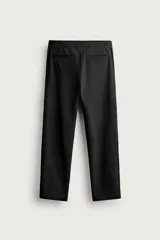 Pantalón negro confeccionado en mezcla de algodón, con cintura elástica, bolsillos frontales y cierre con cremallera y botón.