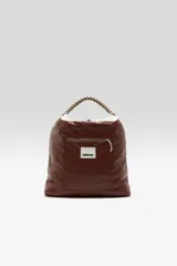 Bolso estilo tote con cuerpo de piel sintética afelpada en color blanco en la parte superior y marrón claro en la base, con asas de mano de cinta marrón.