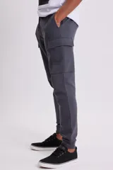 Pantalón estilo jogger en color gris oscuro, con diseño cargo que incluye bolsillos laterales amplios. Cuenta con cintura elástica con cordón ajustable y puños acanalados en los tobillos.