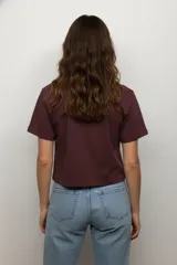 Remera de algodón color beige con cuello redondo y mangas cortas. Presenta un estampado frontal de dos cerezas con diseño de animal print de leopardo.