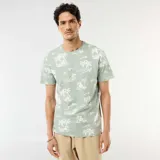 Camiseta verde claro con cuello redondo, manga corta y estampado all-over de estilo tropical con palmeras y paisajes costeros.
