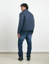Campera capitoneada de color azul oscuro, con cierre frontal de metal y botones a presión. Presenta bolsillos laterales y en el pecho con cierres metálicos.