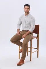Pantalón de gabardina azul marino de corte slim fit y tiro medio, con bolsillos traseros ojalados con botón y presillas para cinturón.