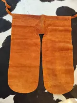 Culero con perneras de cuero marrón gamuzado, diseñado con tiras laterales para atar a la cintura.