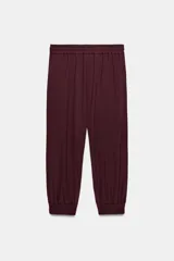Pantalón jogger de tiro medio, color bordó, con cintura elástica ajustable mediante cordones, bolsillos delanteros y puños elásticos en los tobillos.