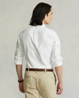 Camisa blanca de corte clásico, confeccionada en tejido oxford de algodón. Presenta cuello button-down, manga larga con puños abotonados y logo bordado en el pecho.