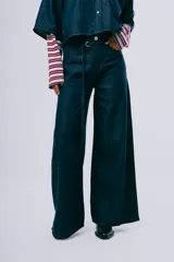 Pantalón wideleg de denim azul oscuro, de tiro alto y corte amplio con bolsillos laterales y cinturón incorporado.