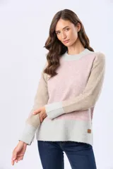 Buzo tejido de punto con diseño de bloques de color en tonos rosa, beige y gris. Presenta cuello redondo, mangas largas y puños acanalados.