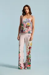 Pantalón Natalia Antolín de corte recto y tiro alto, color rosado claro con estampado floral colorido en la parte inferior de las piernas.