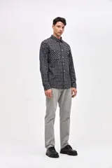 Camisa de corte regular fit confeccionada en algodón, con estampado de cuadros, cuello solapa clásico, cierre frontal con botones y dos bolsillos en el pecho.