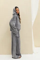 Pantalón gris con efecto acid wash, tiro alto con cintura elástica fruncida, corte amplio tipo palazzo y grandes bolsillos frontales aplicados.