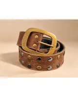 Cinto de cuero marrón con tachas metálicas alternadas en tonos dorados y plateados, hebilla rectangular grande de metal envejecido.