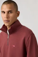 Buzo de algodón color bordó con cuello alto y cierre frontal parcial de un cuarto. Presenta un diseño liso con el logo de la marca bordado en pequeño en el pecho.