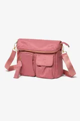 Cartera bandolera de tela color rosa, con múltiples bolsillos frontales, cierre principal y correa ajustable al tono.