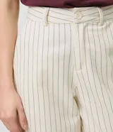 Pantalón wide leg de sarga color beige con estampado a rayas verticales oscuras, de cintura alta con pinzas frontales, bolsillos posteriores y calce amplio.