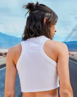 Top corto blanco de morley con escote redondo y logo metálico de Renée en el frente.