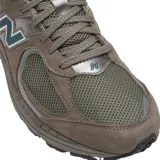 Championes urbanos New Balance modelo 2002R, color marrón con detalles en verde y gris. Confeccionados en una combinación de gamuza y malla, cuentan con el logo 'N' característico en los laterales y tecnología de amortiguación en la entresuela.
