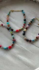 Collar corto con cuentas de colores y cadena de ajuste.