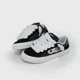 Zapatillas de estilo skate Venefo, color negro con detalles en blanco. Presentan cordones anchos, suela de goma blanca y diseño con logo lateral.