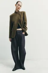 Blazer estructurado de corte recto confeccionado en tejido con lana, con estampado de cuadros en tonos tierra. Presenta cuello subido, cierre frontal con un botón, bolsillos con solapa en la parte inferior y un bolsillo de vivo en el pecho.