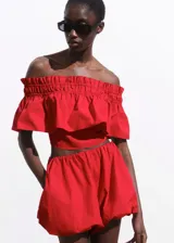 Top corto de algodón color rojo, con diseño off-shoulder, cuello fruncido y detalle de volante en el pecho.