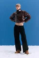 Campera puffer corta de poliamida con acabado brillante, cuello alto y cierre frontal. Presenta un diseño inflado y liviano con corte a la cintura.