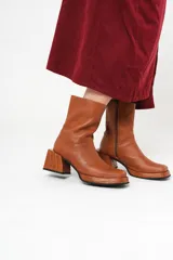 Bota de cuero color marrón con caña media, plataforma delantera de 2 cm y taco cuadrado de 7 cm.