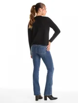 Cardigan tejido de punto color beige, con cuello a la base y cierre frontal mediante un botón metálico decorativo. Presenta mangas largas y corte recto.