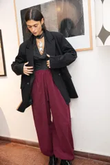 Pantalón tipo babucha de silueta relajada, color bordo, con cintura elástica ajustable mediante cordón y elásticos en los tobillos que generan un efecto abuchonado. Confeccionado en tela suave con acabado tipo piel de durazno.
