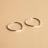Aros tipo argolla de diseño minimalista, fabricados en plata 925 con acabado pulido.