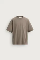 Camiseta boxy fit color verde militar con efecto lavado, confeccionada en tejido compacto de algodón, con cuello redondo y manga corta.
