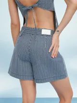 Short de tiro alto con estampado de rayas verticales finas en azul marino y blanco. Presenta un lazo a juego en la cintura y un corte holgado.